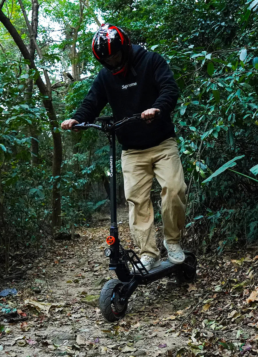 A_man_is_riding_an_Electric-Scooter-IWAFO-IS1_on_the_rough_road_in_the_forest